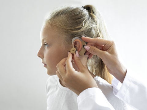 Child being fitted with a hearing aid