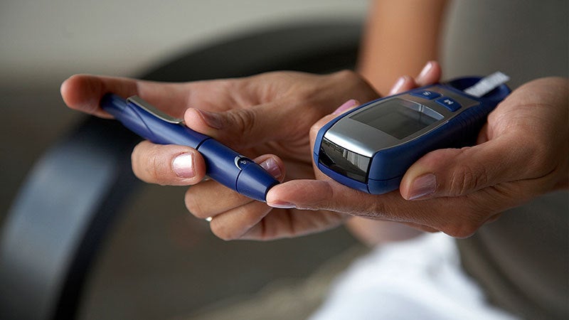 Person using a machine to check their blood sugar