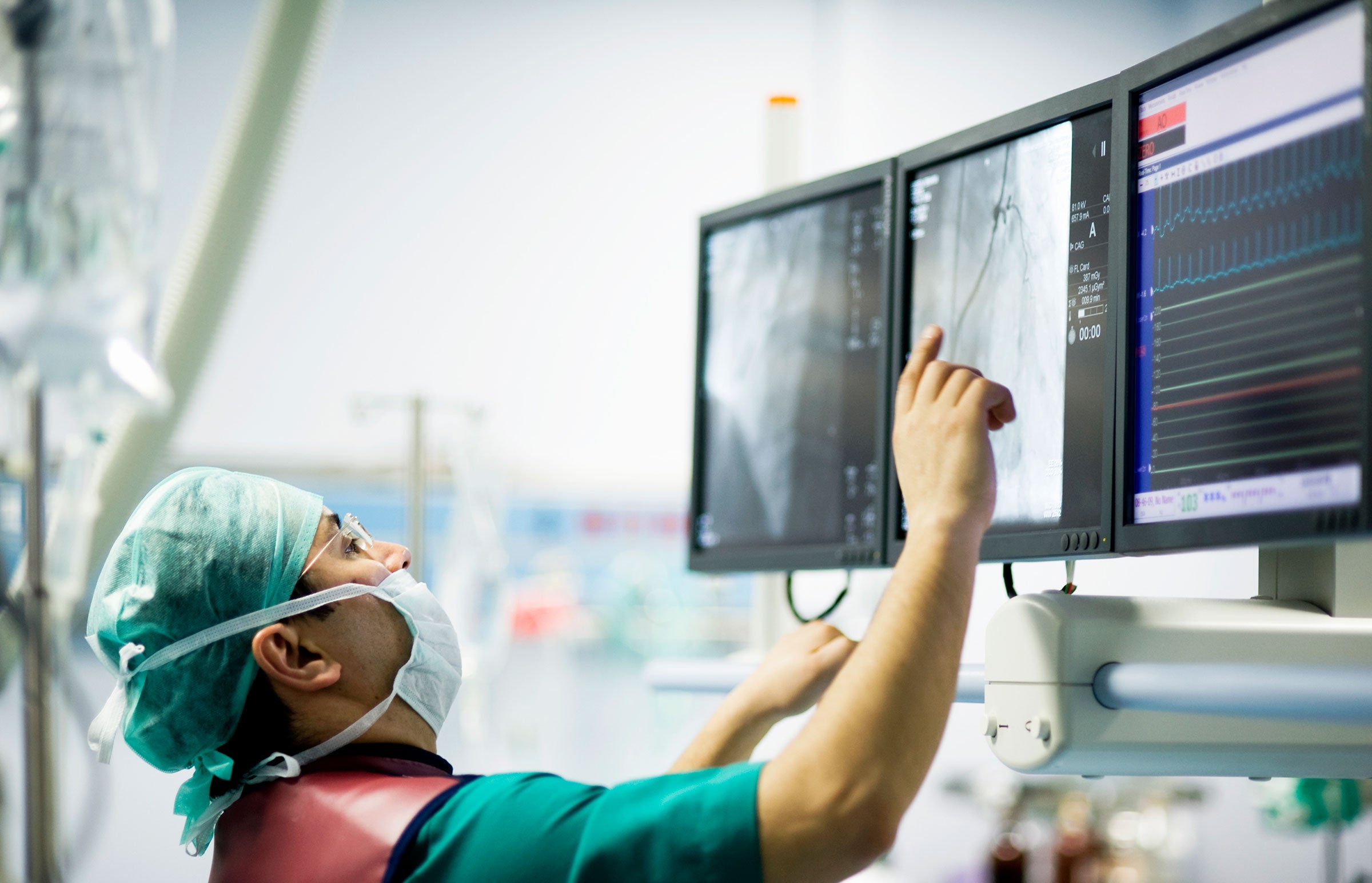 A surgeon is reviewing images on a computer screen