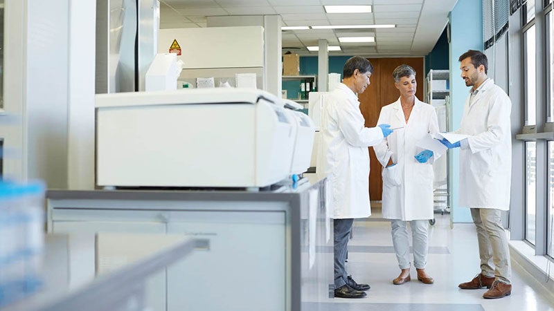 Three medical professionals having a discussion in the hospital hallway