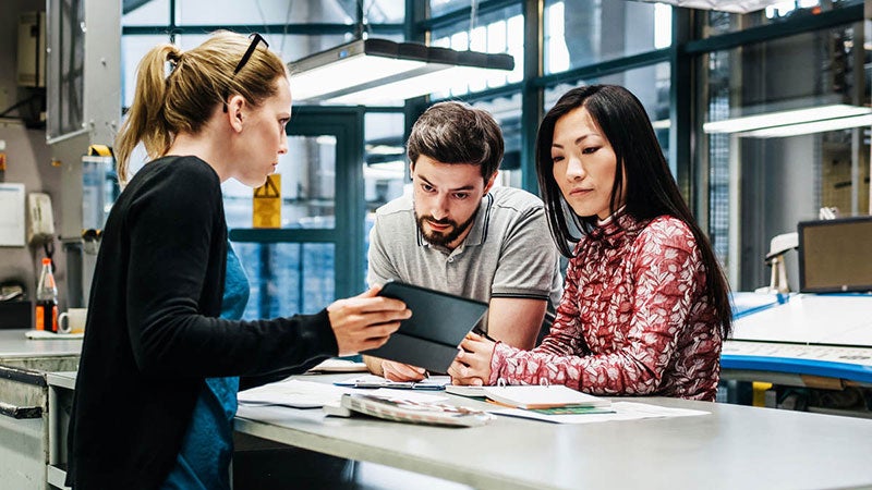 The people having a discussion while looking at a tablet