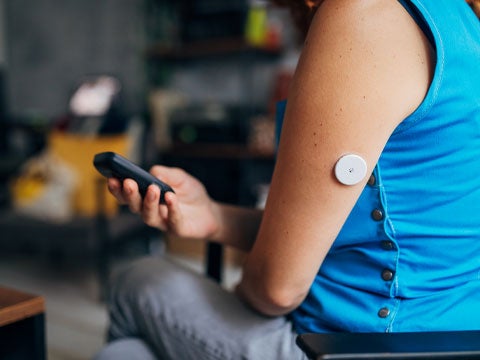 Closeup of an arm wearing a blood sugar testing device