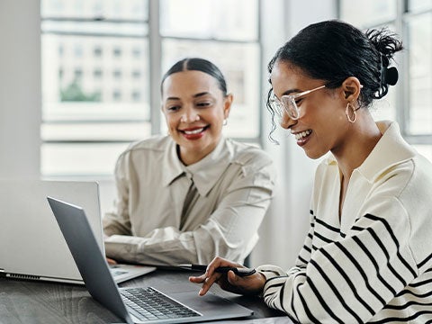 Two people collaborating on their laptops