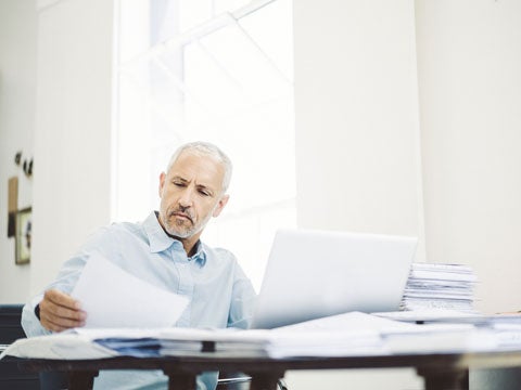 Person reviewing paperwork while sitting at their desk