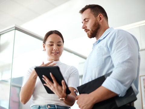 Two business colleagues collaborating over a tablet