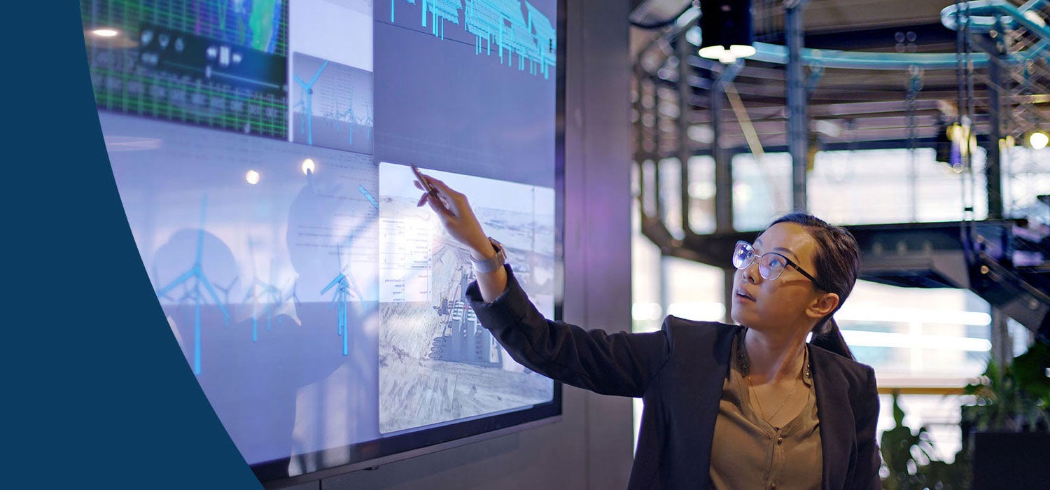 Person pointing to a graph on a large tv screen