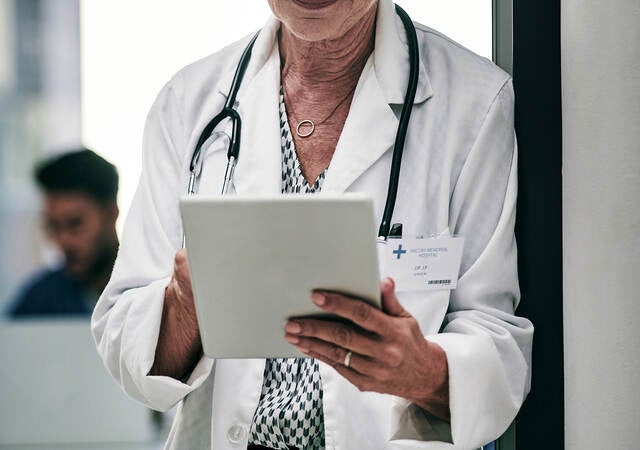 Doctor looking at a tablet screen.