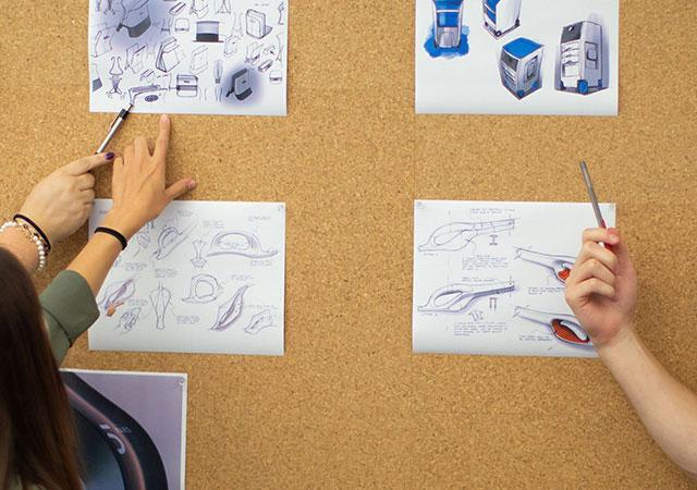 Going over designs on a bulletin board.