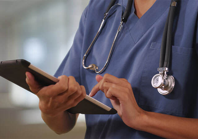 Doctor doing work on a tablet.