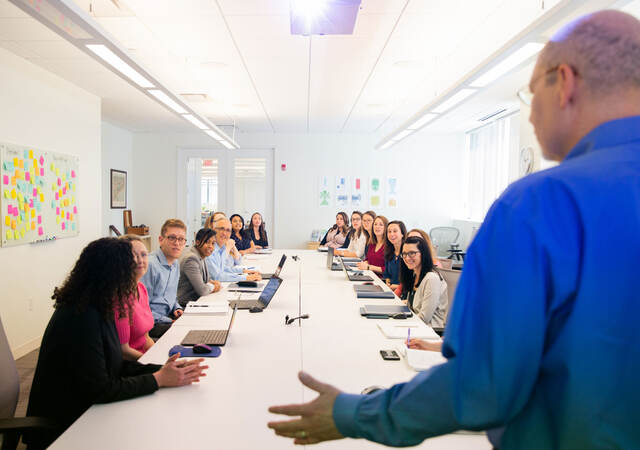 Person presenting to a conference room full of people