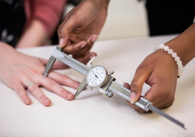 Doctor measuring the length of a patient's finger
