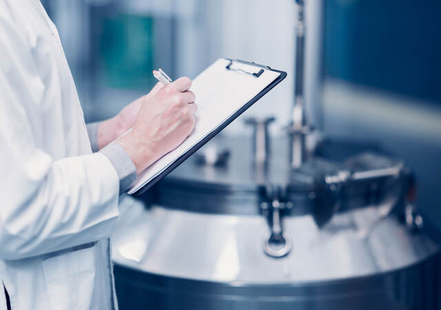 Scientist writing notes on a clipboard