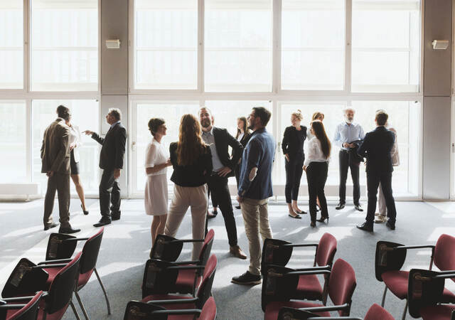 Group of business professionals greeting each other and shaking hands 