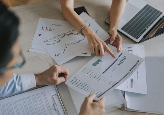 Group of people meeting and discussing graphs