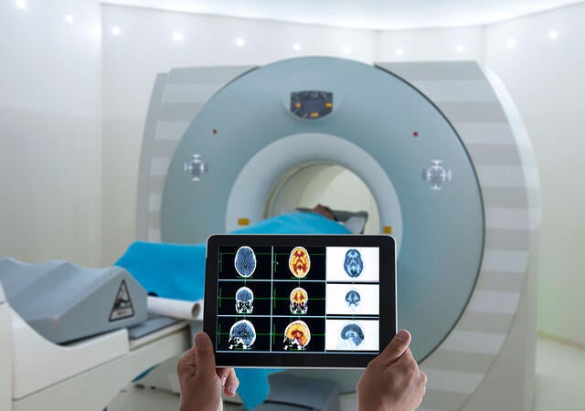 Medical professional reviewing CT scans on a tablet