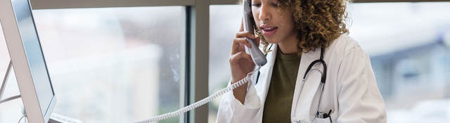 Doctor sitting at desk on the phone