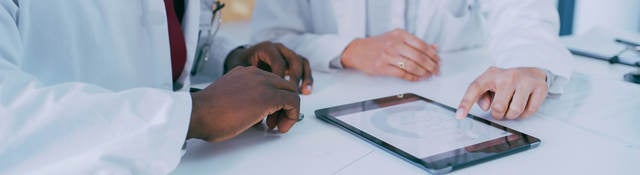 Two medical professionals using a digital tablet