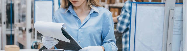 Technician in a lab reviewing notes