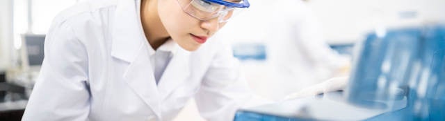 Lab technician wearing safety goggles staring at a test