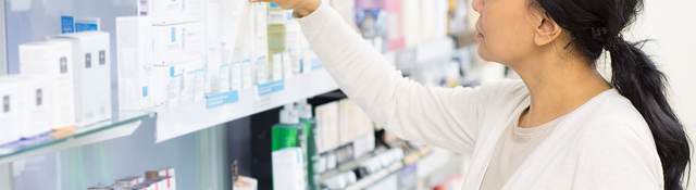 Customer grabbing medicine off the shelf at a store