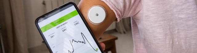 Phone with app being used for blood glucose monitoring.