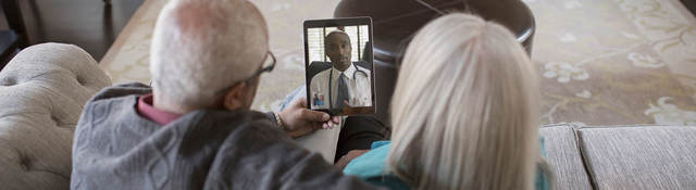 Two people having a virtual visit with their doctor