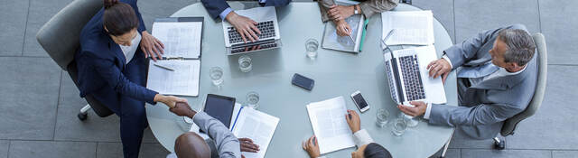 Overhead view of business people sitting around a conference table while working