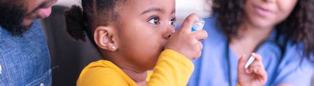 Child using an inhaler with the help of a doctor