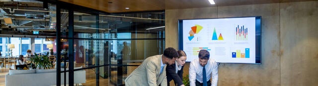 Three business colleagues reviewing metrics in a meeting
