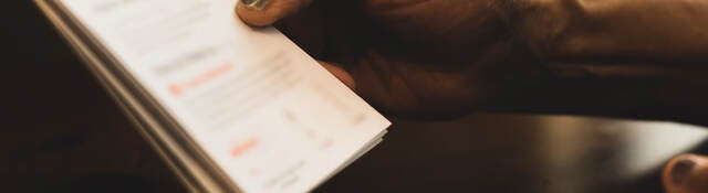 Human hand holding a set of instructions