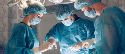 Surgeons surrounding a patient