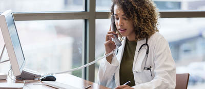 Doctor sitting at desk on the phone