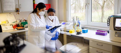 Two lab technicians looking at a clipboard
