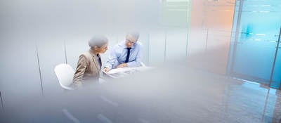 Two people reviewing a document in a conference room