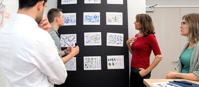 People reviewing plans on a wall