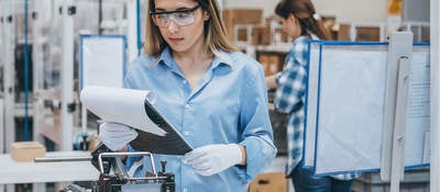 Technician in a lab reviewing notes