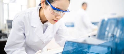 Lab technician wearing safety goggles staring at a test