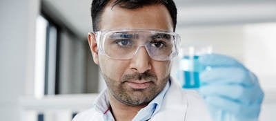 Lab technician holding a beaker with liquid