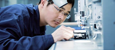 Lab technician placing something under a microscope