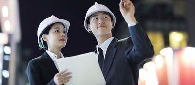 Two people in hardhats interacting