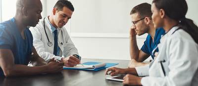 Doctors sitting at a table discussing notes