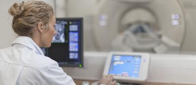 Medical professional using electronic controls to test a medical scanning device.