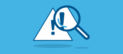 Magnifying glass looking at triangular warning icon