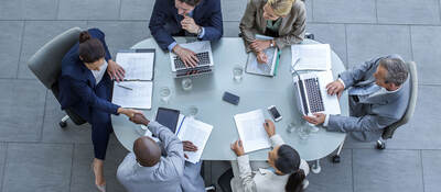 Overhead view of business people sitting around a conference table while working