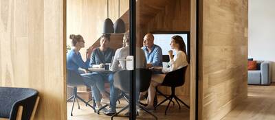 Business executives meeting inside a modern wood paneled conference room