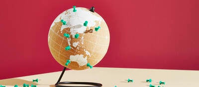 World map on globe with push pins for locations