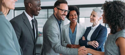 Group of business professionals greeting each other and shaking hands 