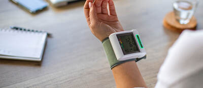 Closeup of a person wearing a blood pressure cuff
