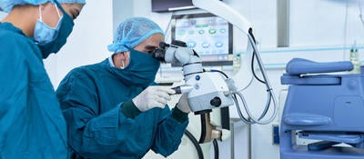 Two ophthalmologists performing operation on a patient's eyes