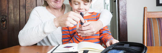 Mother helping son use medical device